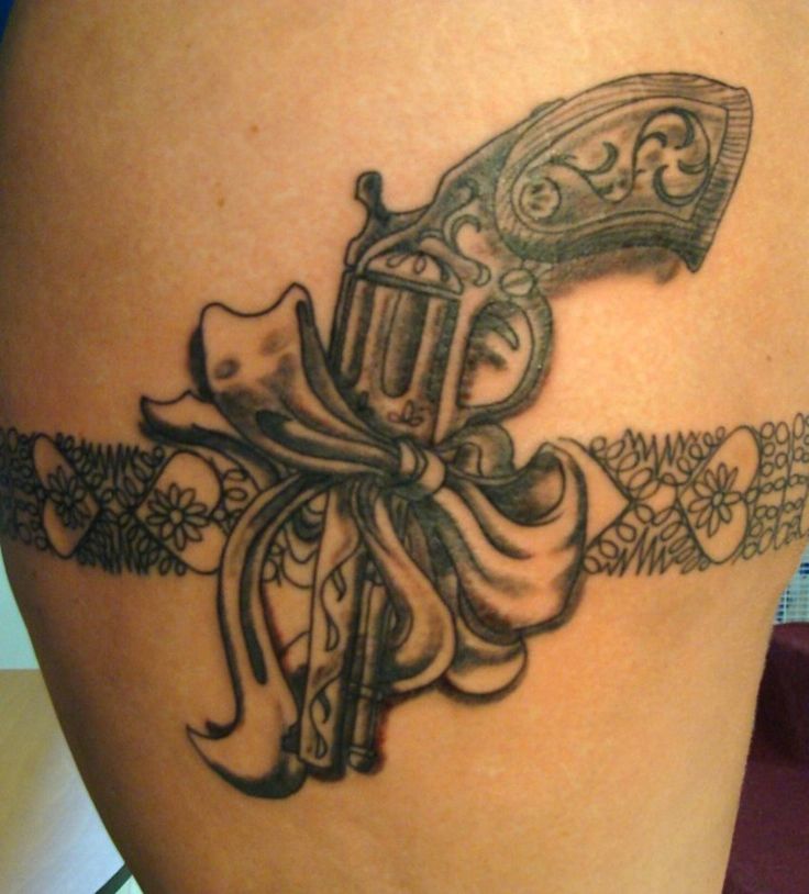 Pistol In Lace Band With Bow Tattoo On Thigh