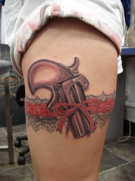 Pistol Tattoo With Red Ribbon Lace band On Thigh