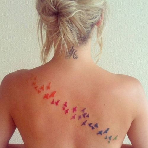 Purple And Pink Flock Of Birds Tattoo On Girls Back