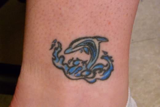 Small Dolphin And Water Wave Tattoo On Leg
