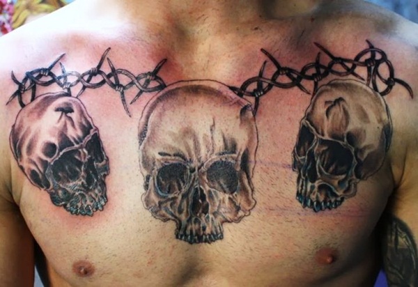 Three Skulls And Barbed Wire Tattoo On Chest