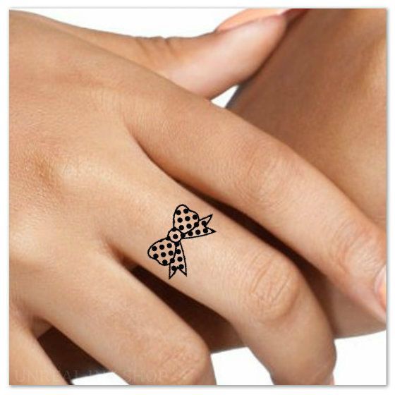 Tiny Dotted Bow Tattoo On Finger