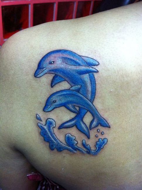 Two Dolphins With Water Wave Tattoo On Back Shoulder