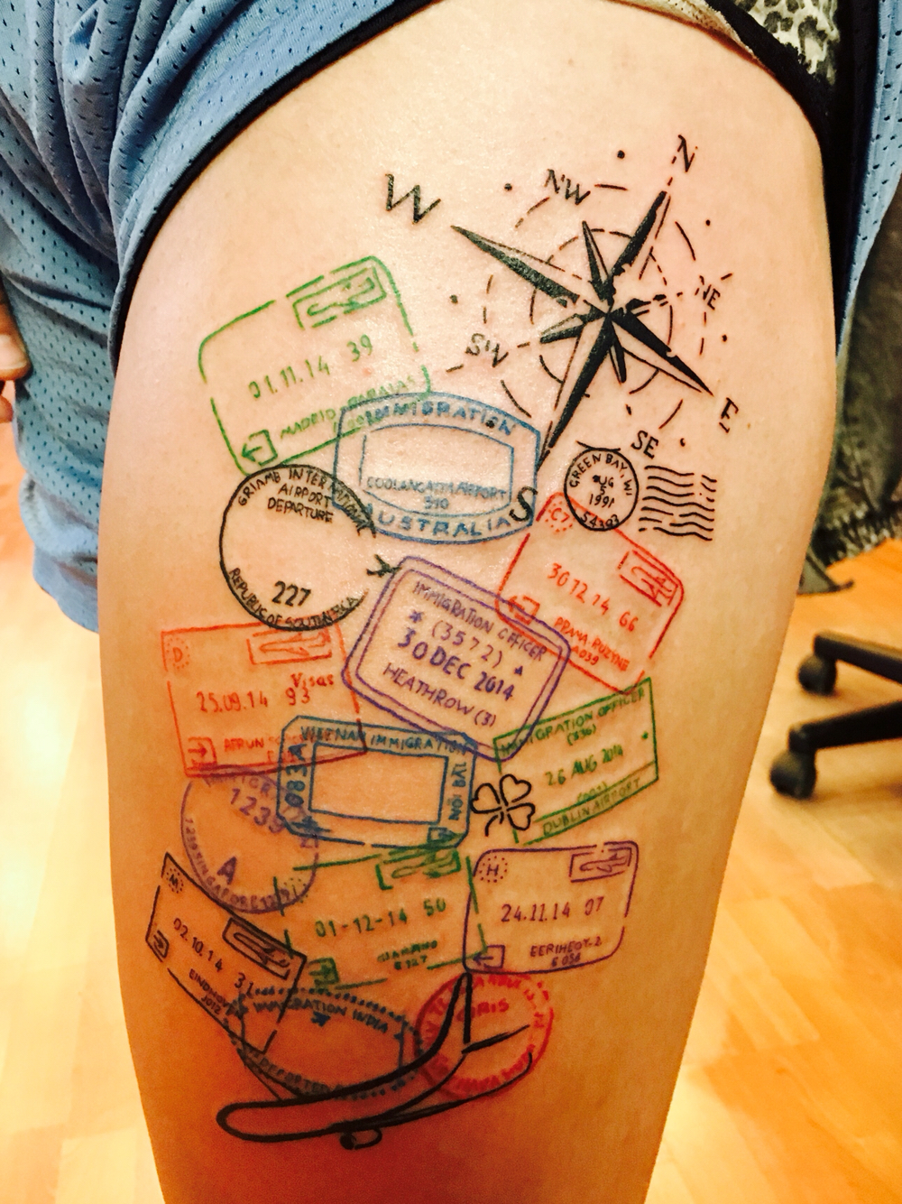Compass – Airplane With Colorful Passport Stamps Tattoo on Thigh by Marc Nelson