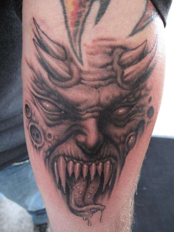 Grey ink Demon Face Tattoo On Leg