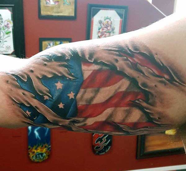 Ripped Skin USA Flag Tattoo On Bicep For Men