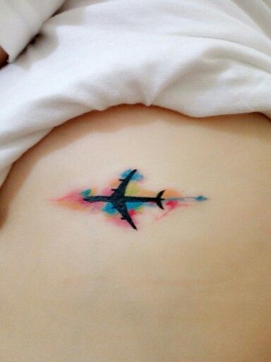 Small Black Airplane In Colorful Clouds Travel Tattoo