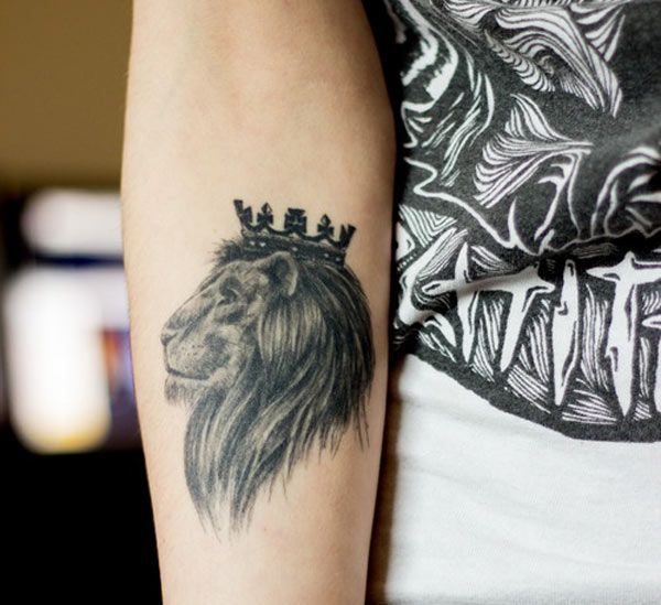 Small Gray Ink Lion With Crown Tattoo On Forearm