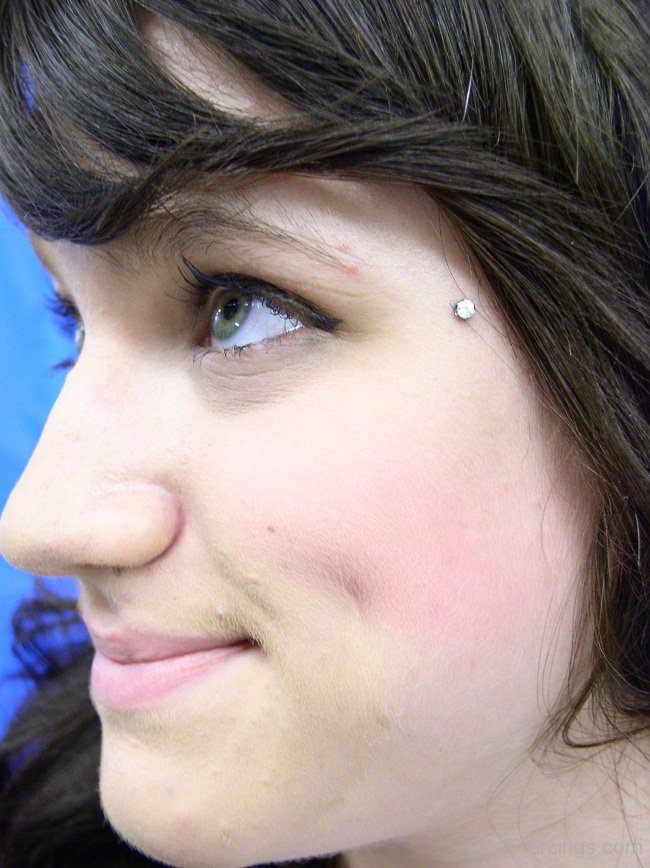 Dermal Anti-Eyebrow Piercing On Girl Left Side