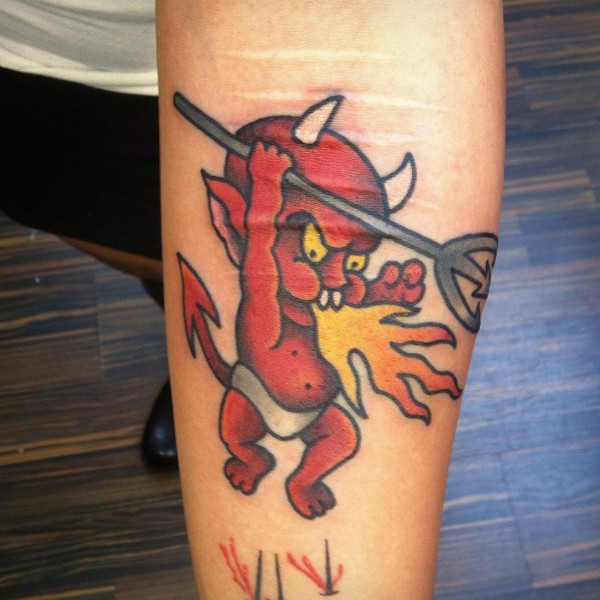Red Baby Devil Exhaling Fire Tattoo On Forearm