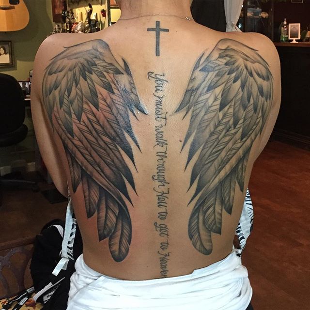Amazing Grey Ink Angel Wings Tattoo On Full Back With Cross & Wording ‘You must walk through hell to get to heaven’