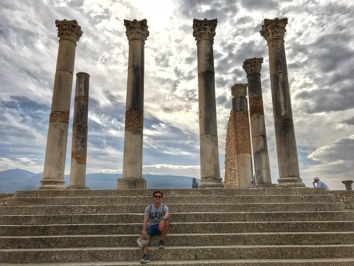 Man Sitting on Stairs Posing For Photograph At The Volubilis