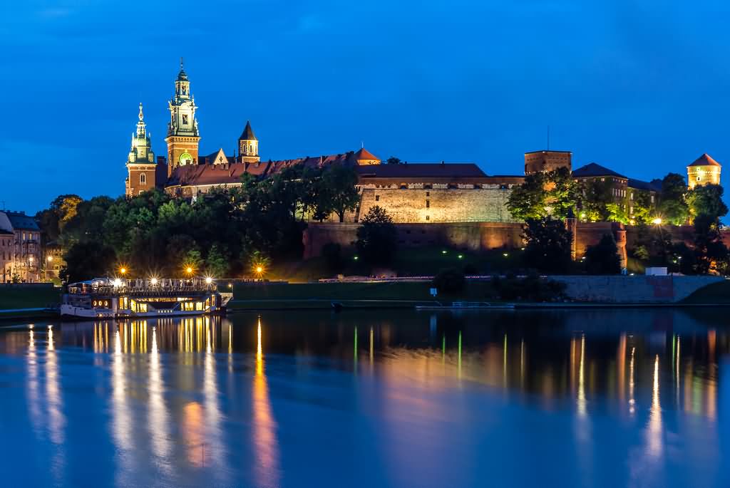 River And Wawel Castle Illuminated By Night