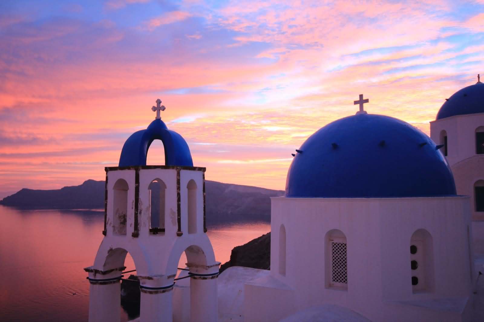 Blue Domes Of Church During Sunset In Santorini, Greece