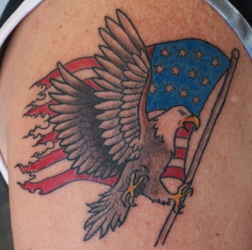 Grey Ink Bald Eagle Carrying American Flag Tattoo