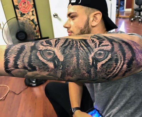 Grey Ink Realistic Tiger Eyes Tattoo On Guy’s Forearm