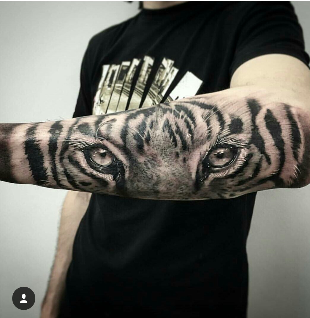 Grey Ink Tiger Eyes Tattoo On Man Outer Forearm