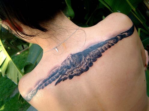 Black & Grey Ink Realistic Flying Eagle Front View Tattoo Design On Girl Upper Back