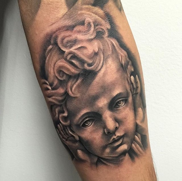 Grey Ink 3D Cherub Face Tattoo On Forearm By Chunk At Certified Tattoo Studios Denver Colorado