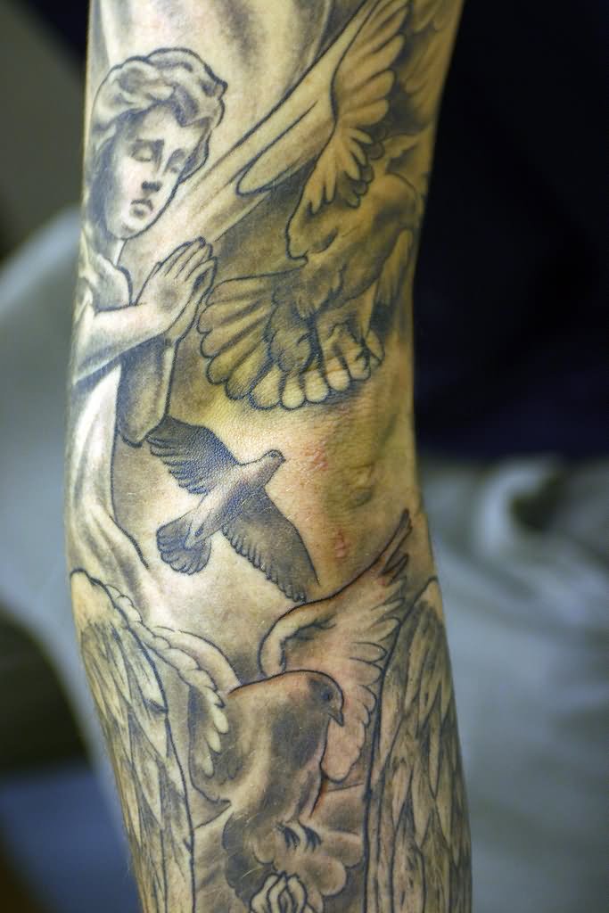 Grey Ink Doves and Praying Cherub Tattoo On Arm by Flaming Art Tattoo