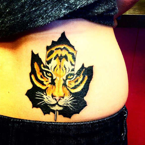Yellow Tiger Head In Black Maple Leaf Tattoo On Lower Back