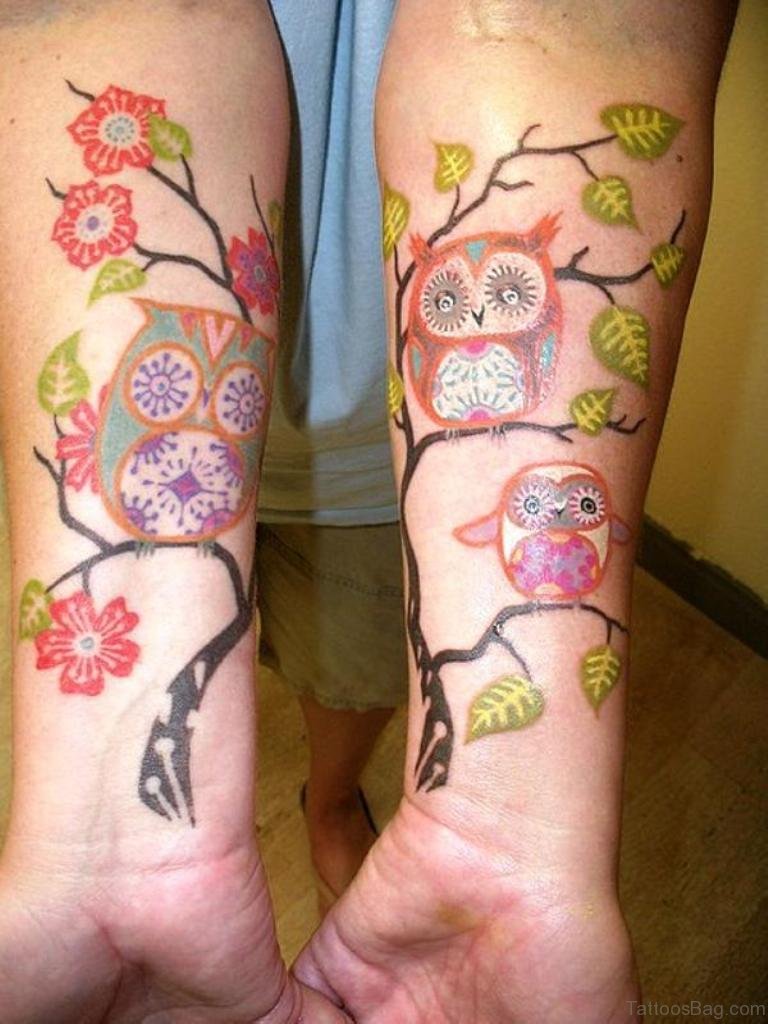 Amazing Colorful Owl & Baby Owls Sitting On Floral Branches Tattoo On Forearms