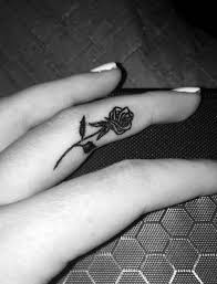 Small Cute Black Rose Tattoo On Girl Middle Finger