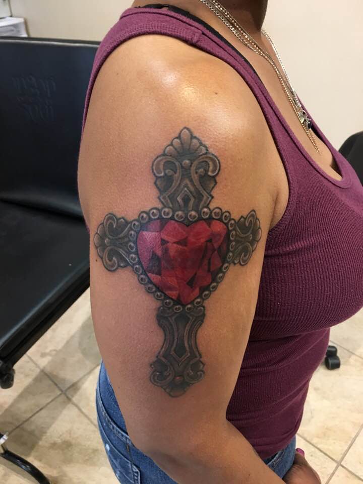 Wonderful Black Ink Antique Metallic Cross With Red Heart At Center Tattoo