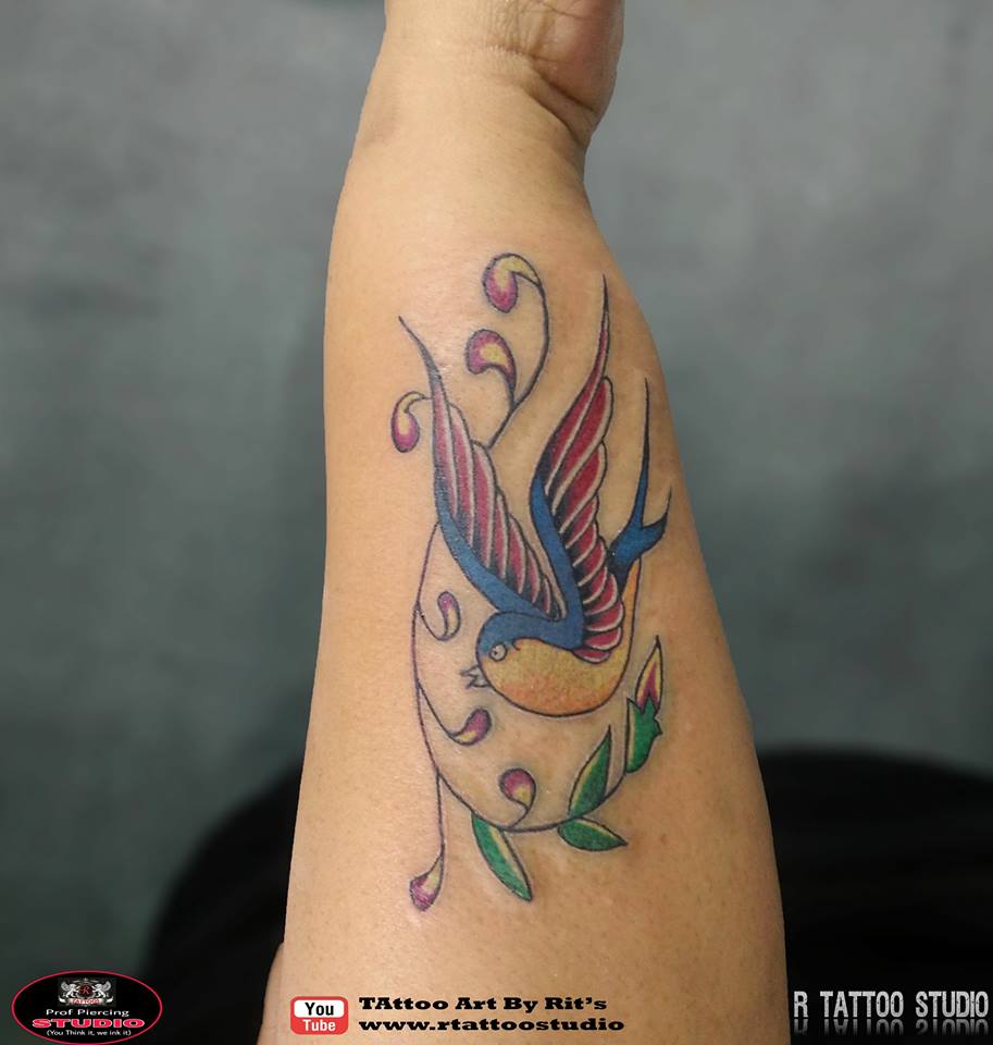Bird tattoo on outer forearm