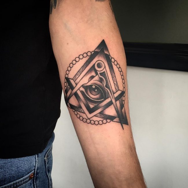 An Unique Black Ink Illuminati Tattoo On Male Forearm