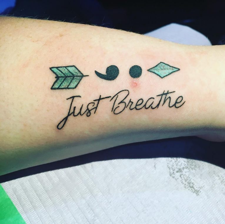 Arrow & Semicolon With Wording 'Just Breathe' Tattoo On Arm.