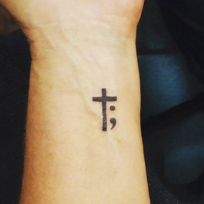 Black Ink Cross And Semicolon Tattoo On Wrist