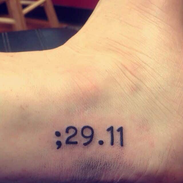 Black Ink Semicolon and Date Tattoo On Foot