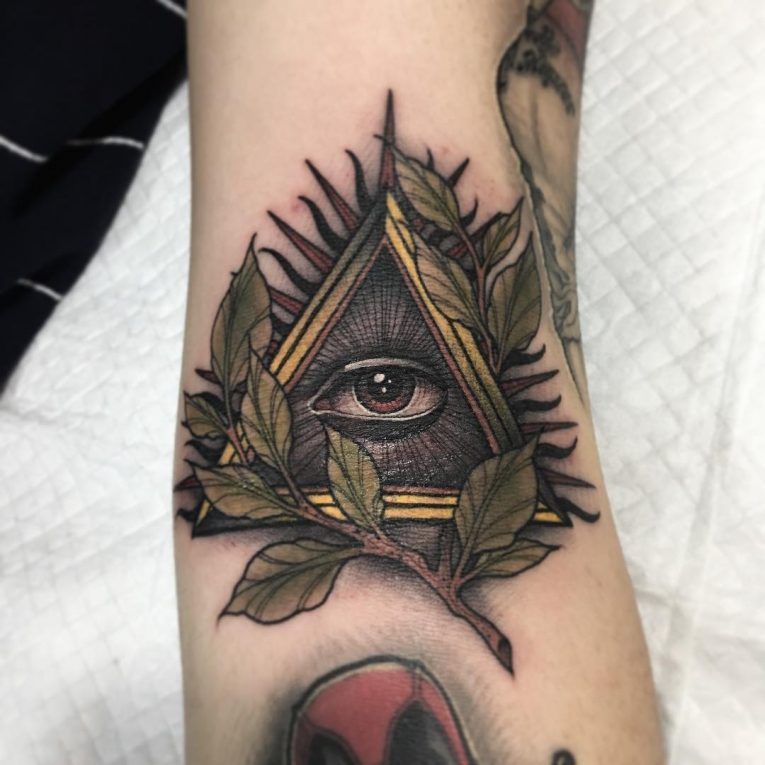 Grey Illuminati With Green Leaves Tattoo On Arm