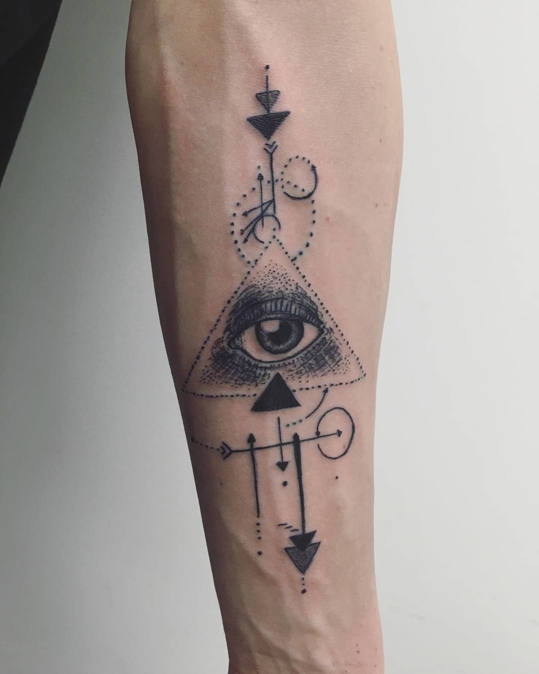 Grey Ink Illuminati Symbol With Geometrical Designs Tattoo On Male Forearm