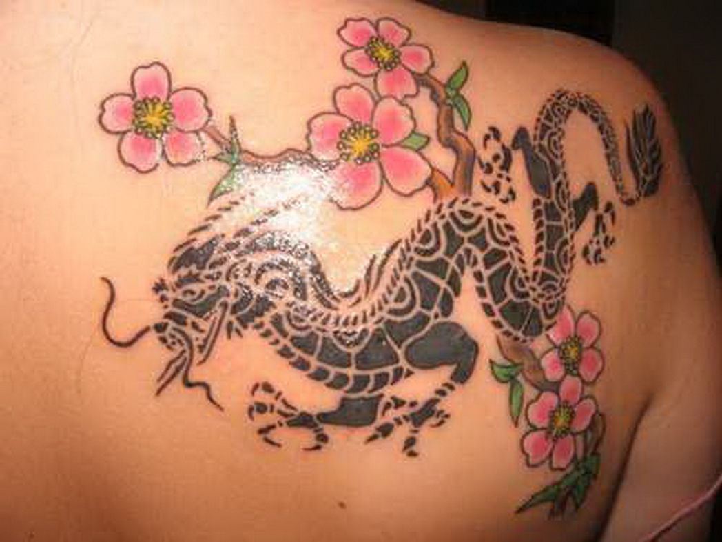 Black Tribal Dragon With Oink Flowers Women Tattoo On Back Shoulder