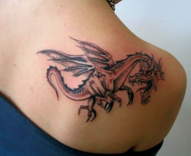 Black and red small tribal dragon tattoo on right shoulder