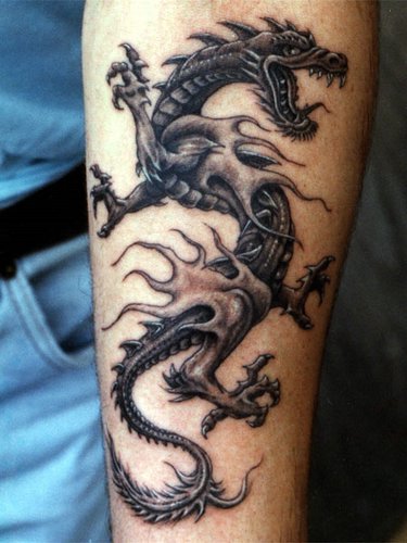 Black and white dragon tattoo on inner forearm
