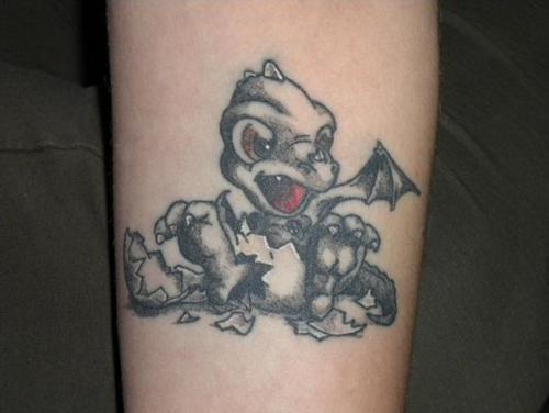 Black baby dragon tattoo on inner arm