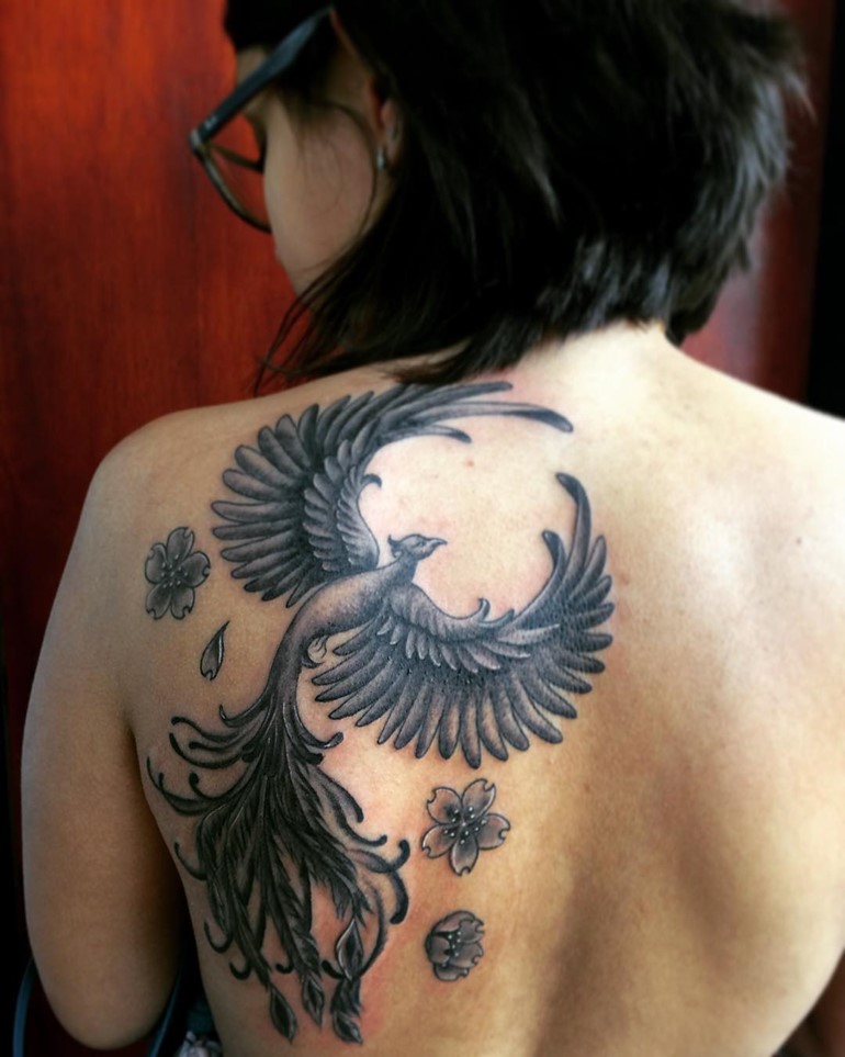 Black feminine rising phoenix and flowers tattoo on girl back