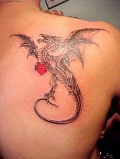 Black flying dragon tattoo with heart on right back ‘shoulder