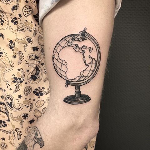 Black globe earth tattoo with grid on left arm
