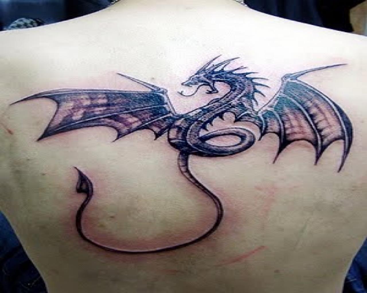 Black ink dragon tattoo on upper back