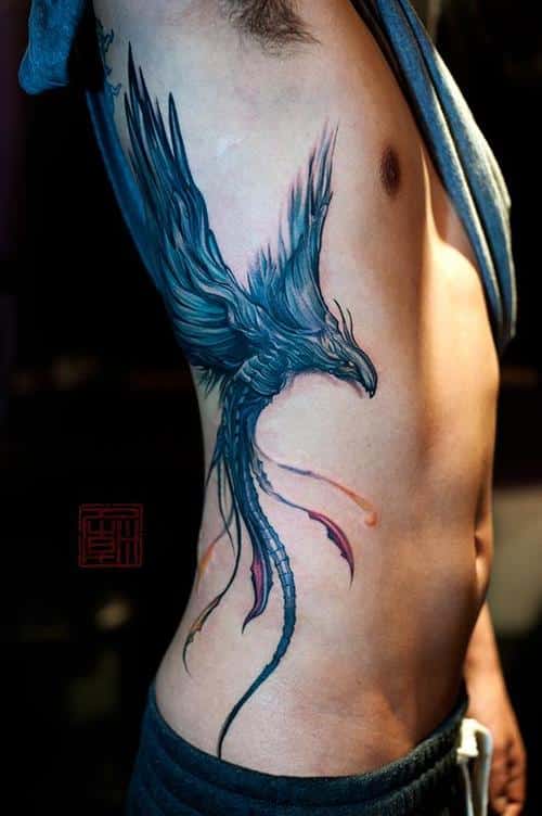 Black ink realistic flying phoenix tattoo on guy’s siderib and back