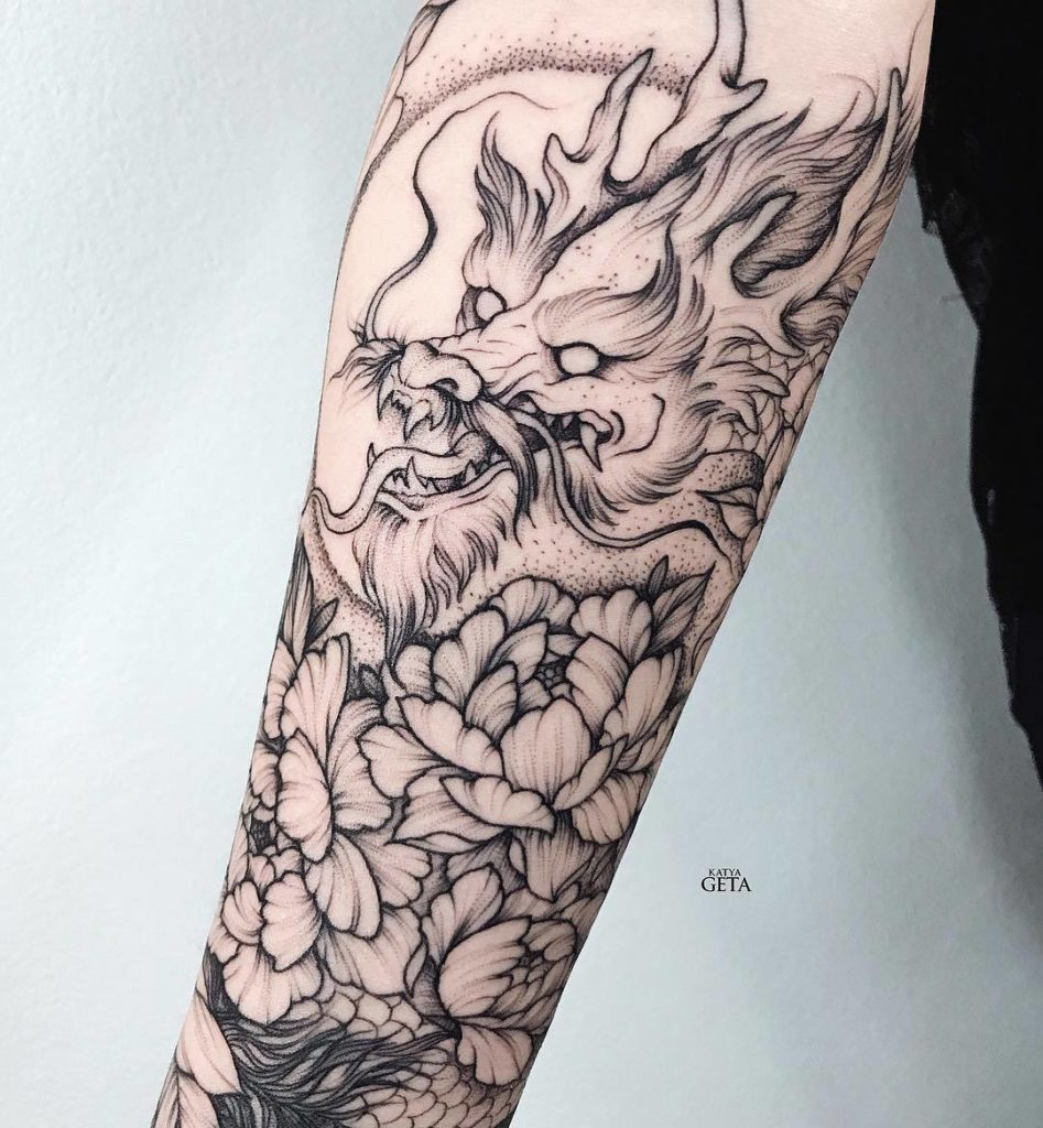 Black outlined dragon flower tattoo on inner forearm