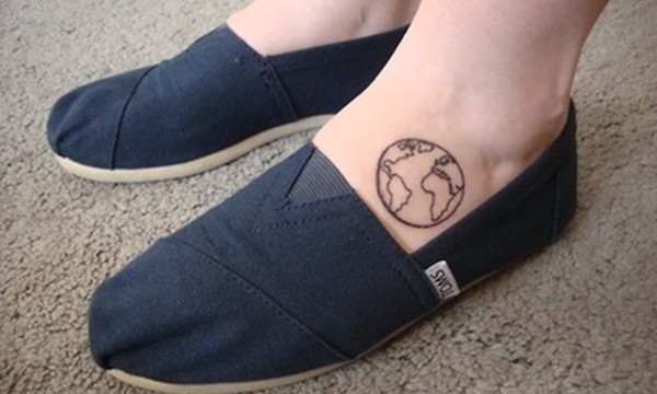 Black outlined small earth tattoo on left foot