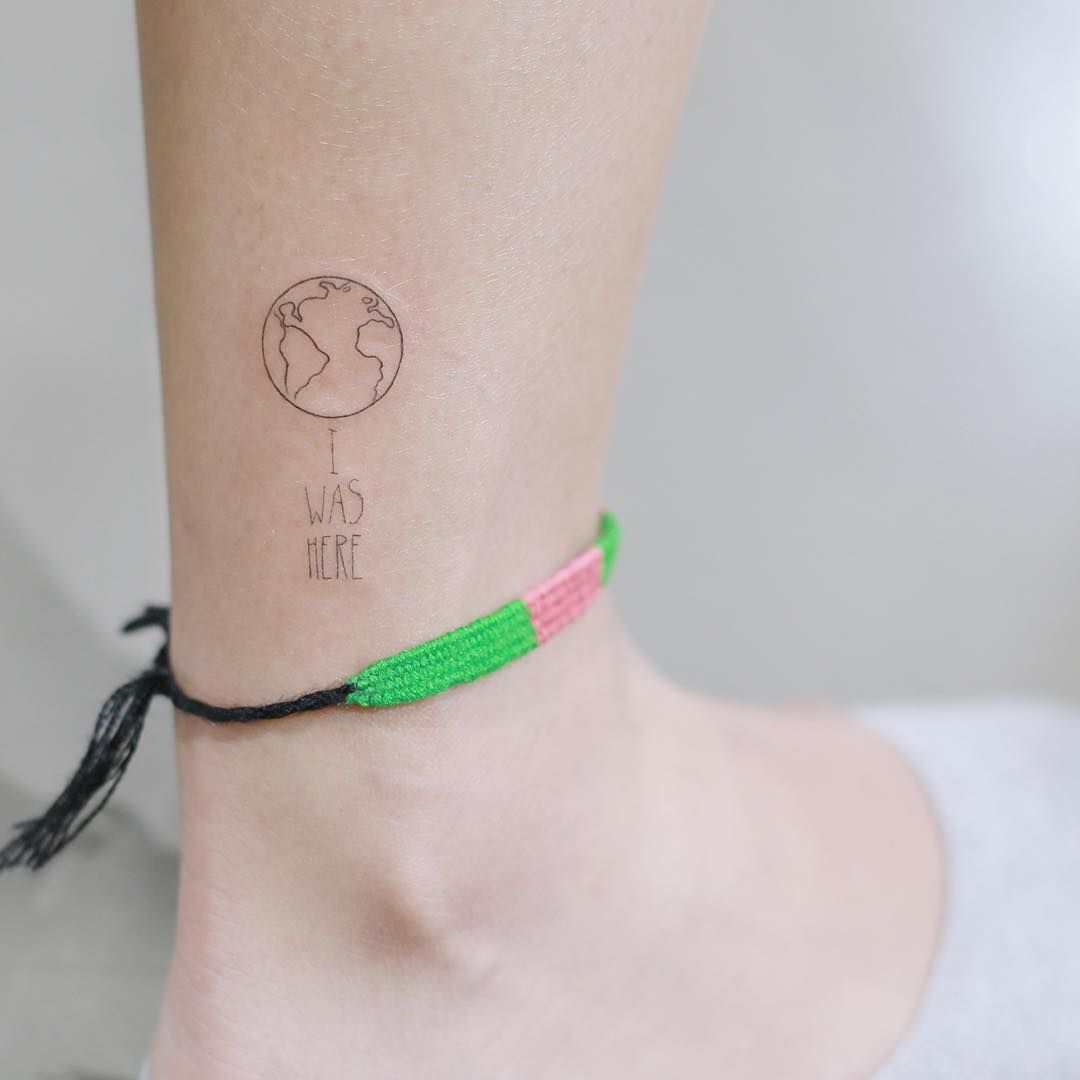 Black outlined small earth tattoo on right leg for women