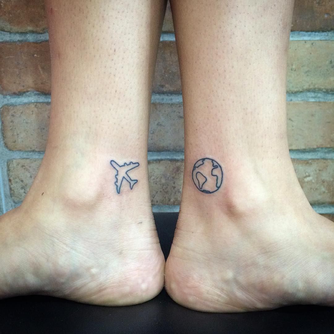 Black pair of globe and airplane tattoo on feet