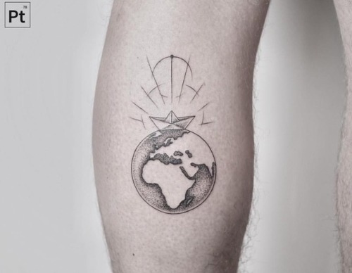 Black shaded earth tattoo with paper ship on inner arm