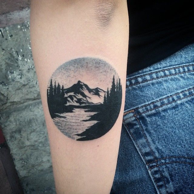 Black shaded earth with scenery tattoo on inner lower sleeve